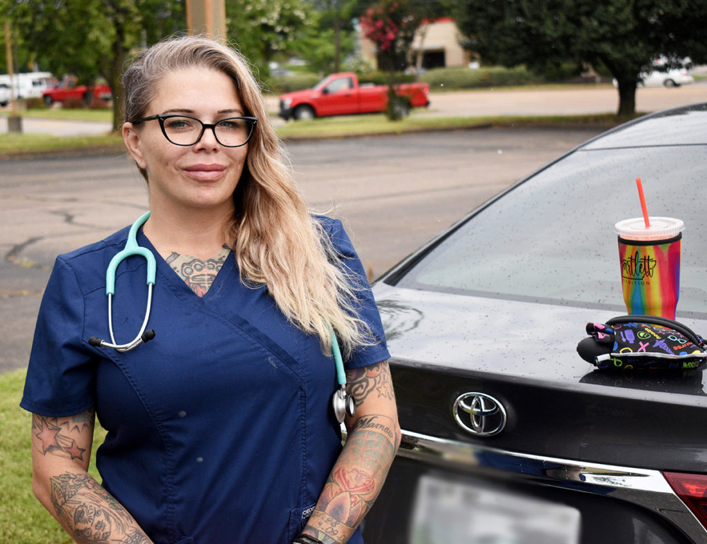 FREE BLOOD PRESSURE CHECKS:  April Brock standing in front of her Toyota Avalon which she has been running her blood pressure station out of. Brock said that being gone so long was hard at first for her family, but now they understand how much she loves healthcare.